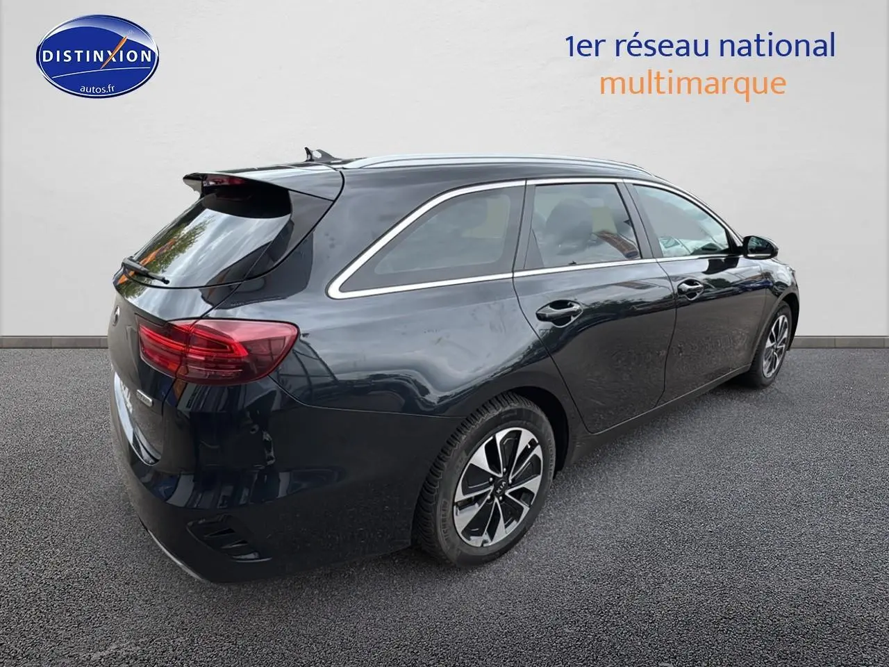 KIA CEE'D SW noire vue 3/4 arrière côté droit, avec barres de toit et feux arrière LED distinctifs.