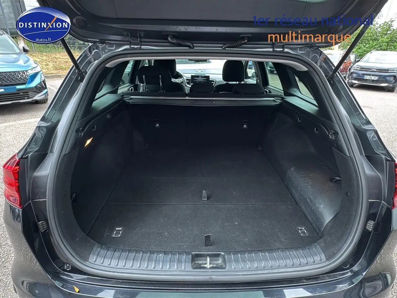 Coffre ouvert vue arrière d'une KIA CEE'D SW noire 2020, espace de chargement spacieux et intérieur sombre.