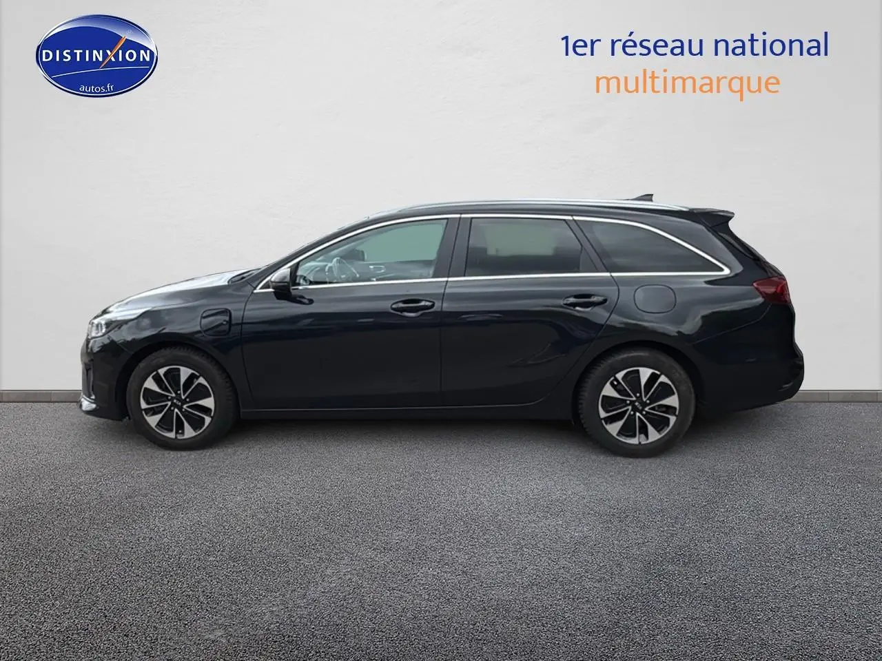 Profil côté gauche d'une Kia CEE'D SW noire 2020 avec jantes alu et barres de toit visibles.