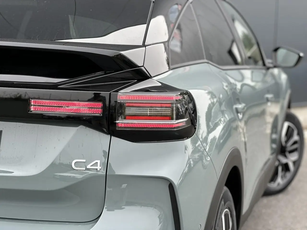 Vue arrière côté droit d'une Citroën C4 Manhattan Green avec toit noir et feux arrière LED distinctifs.