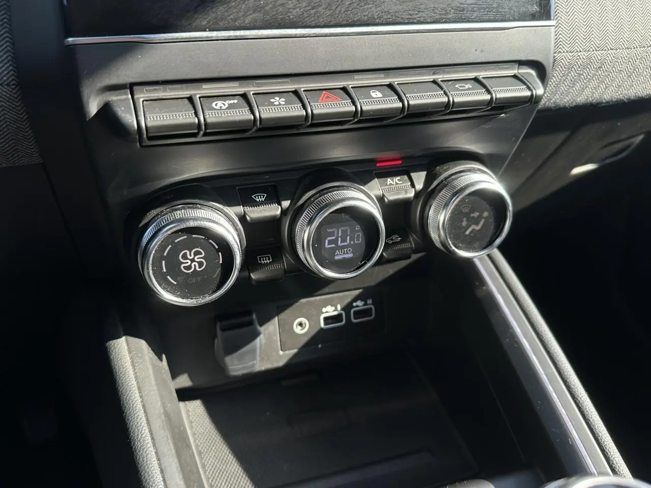 Gros plan sur les commandes de climatisation et boutons multifonctions du tableau de bord de la Renault Clio TCE 90 Techno.