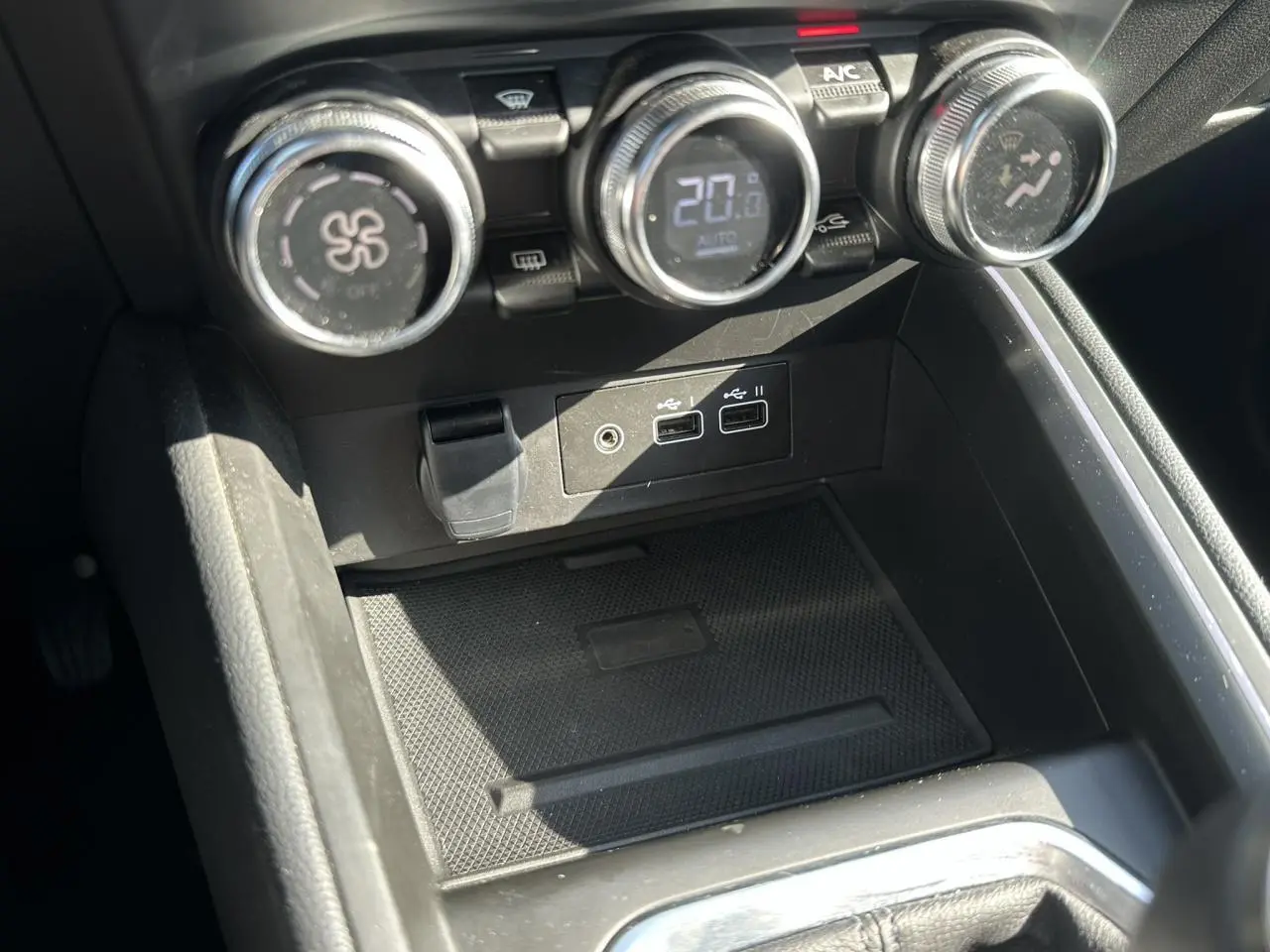 Gros plan sur la console centrale de la Renault Clio TCE 90 Techno avec commandes climatisation et ports USB visibles