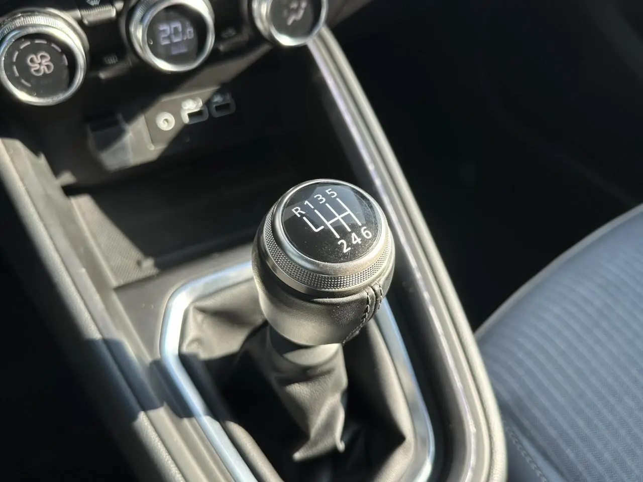 Le levier de vitesses manuel noir de la Renault Clio TCE 90 Techno, vue rapprochée de la console centrale.