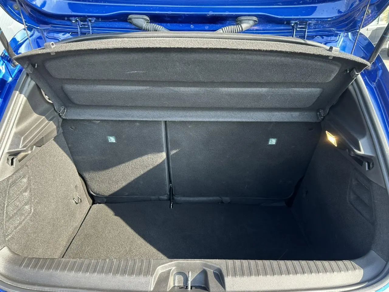 Coffre ouvert vu de l'arrière d'une Renault Clio Bleu Iron 2025, montrant un espace de chargement propre et spacieux.