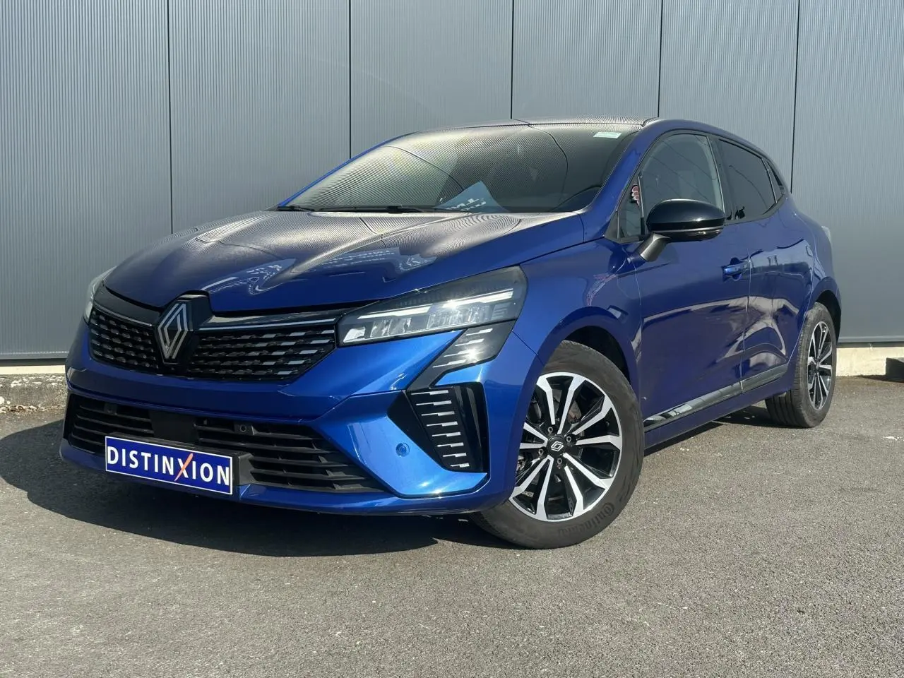 Renault Clio TCE 90 Techno bleu Iron vue 3/4 avant avec jantes alliage et calandre noire distinctive.