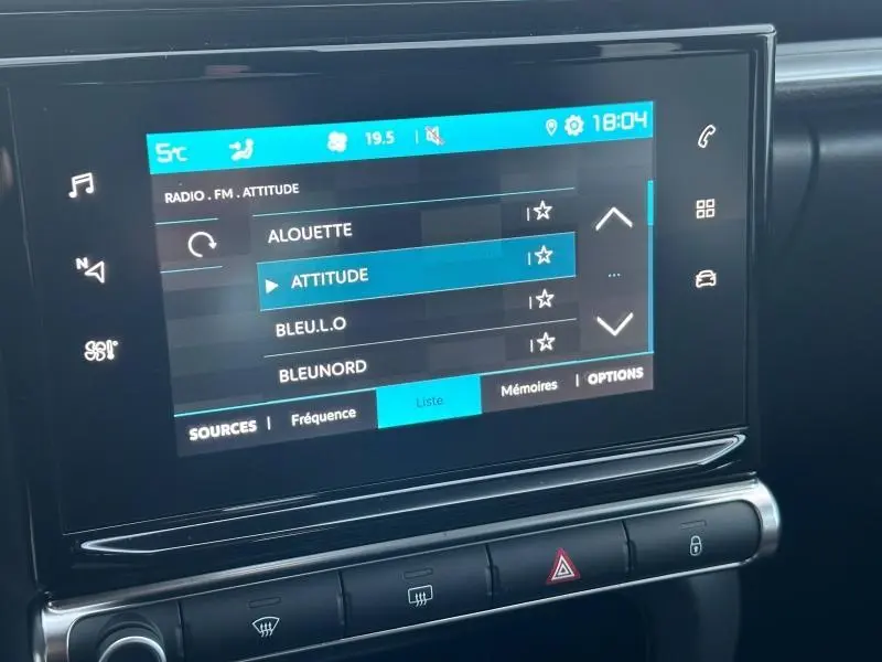 Écran tactile central du tableau de bord de la Citroën C3 2023, affichant la radio FM avec sélection sur la station Attitude.