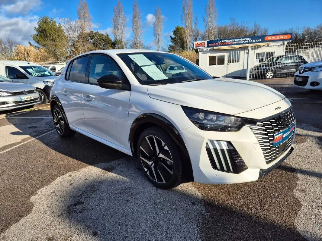 Peugeot 208 Hybrid blanc vue 3/4 avant droit, avec jantes alliage noires et calandre distinctive en concession.