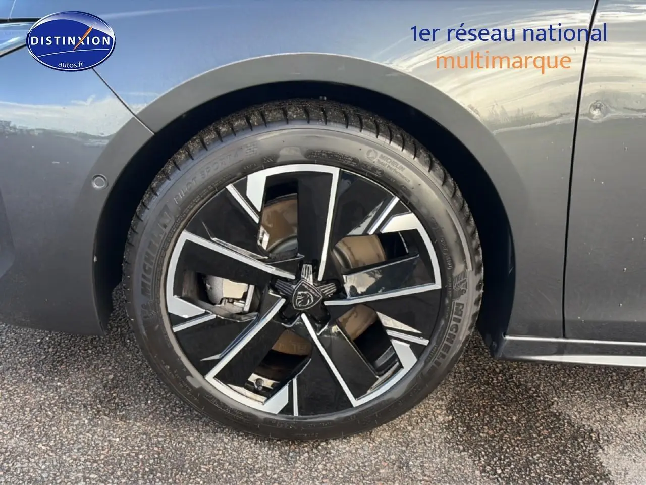 Gros plan sur la jante alu noire et argentée du côté gauche d'une Peugeot 508 Hybrid gris titane 2024.