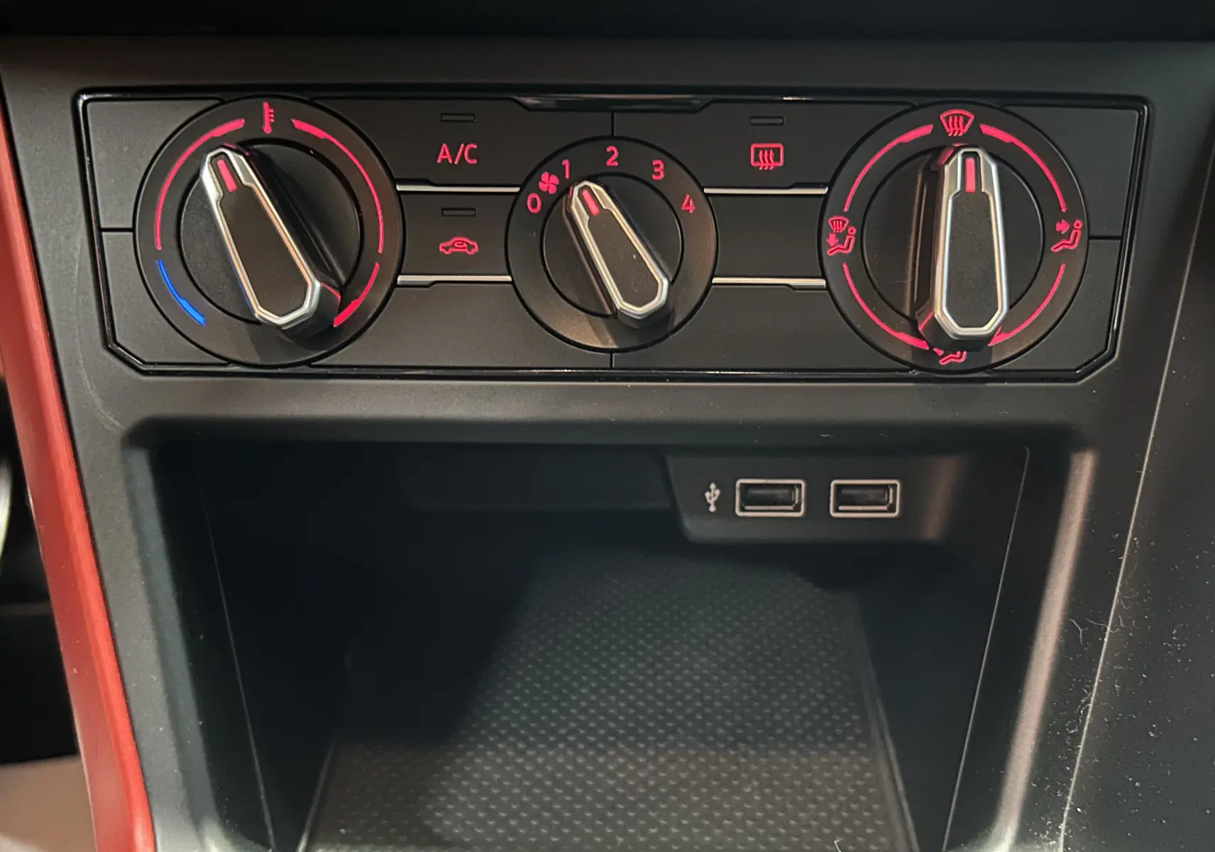 Gros plan sur les commandes de climatisation et deux ports USB du tableau de bord d'une Volkswagen Polo gris.
