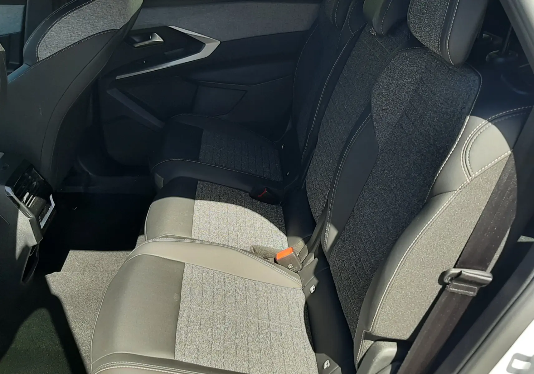 Vue intérieure côté droit des sièges arrière du Peugeot 5008 Hybrid 145ch Allure, tissu gris et cuir noir.