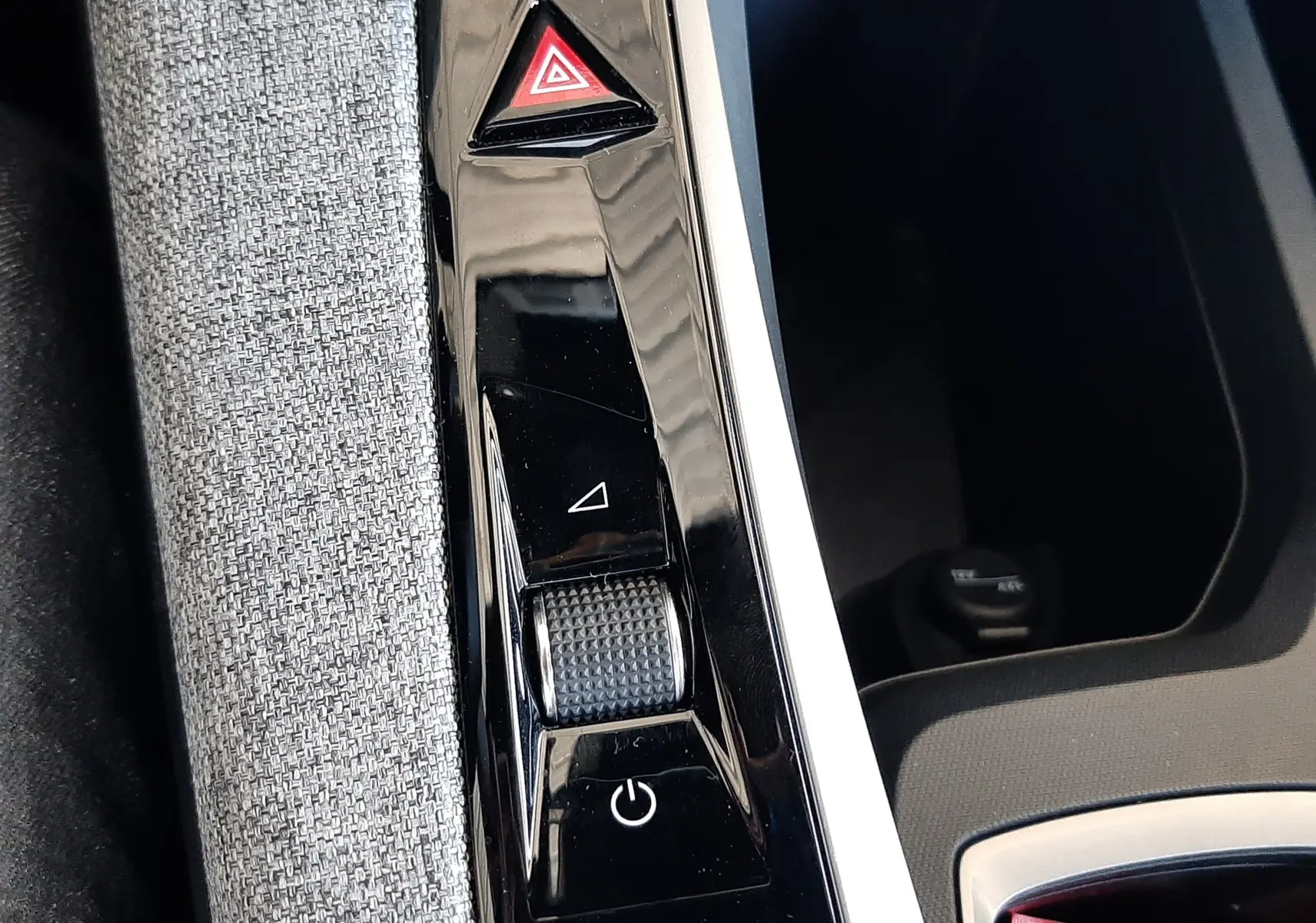 Détail de la console centrale noire brillante du Peugeot 5008 Hybrid 2025 avec molette et bouton de mode de conduite.