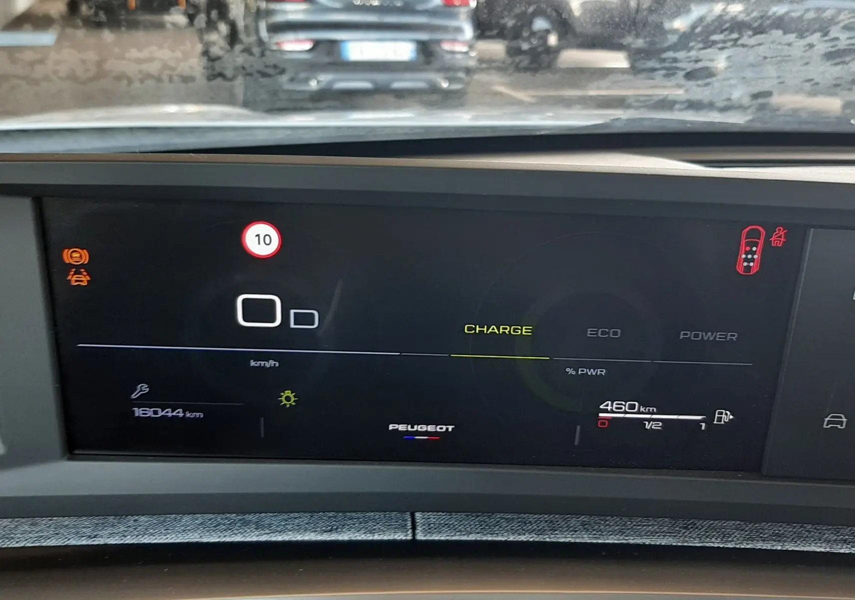 Vue intérieure du tableau de bord numérique du Peugeot 5008 Hybrid 145ch, affichant l'autonomie et les alertes de conduite.