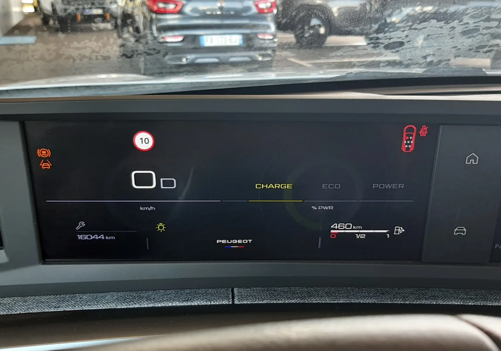 Vue intérieure du tableau de bord numérique du Peugeot 5008 Hybrid 2025, affichant l'autonomie et les modes de conduite.