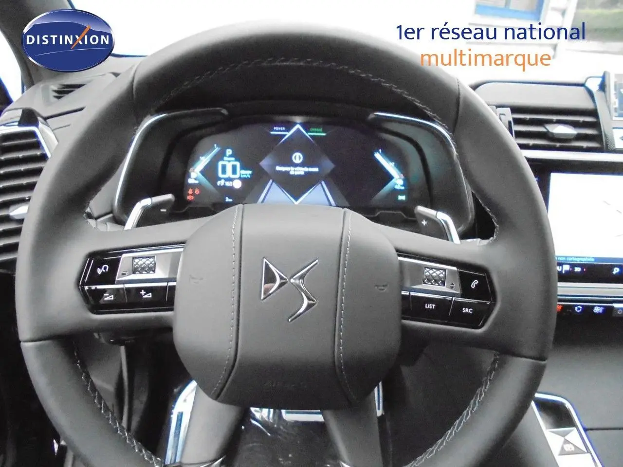 Vue rapprochée du volant DS noir avec commandes intégrées et tableau de bord numérique du DS7 Crossback E-TENSE 2021.