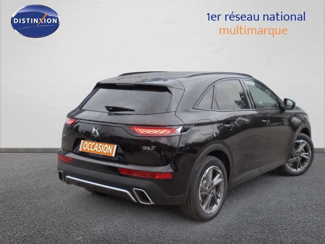 Vue 3/4 arrière droite d’un DS7 Crossback noir perle métal avec feux arrière allumés sur fond neutre.