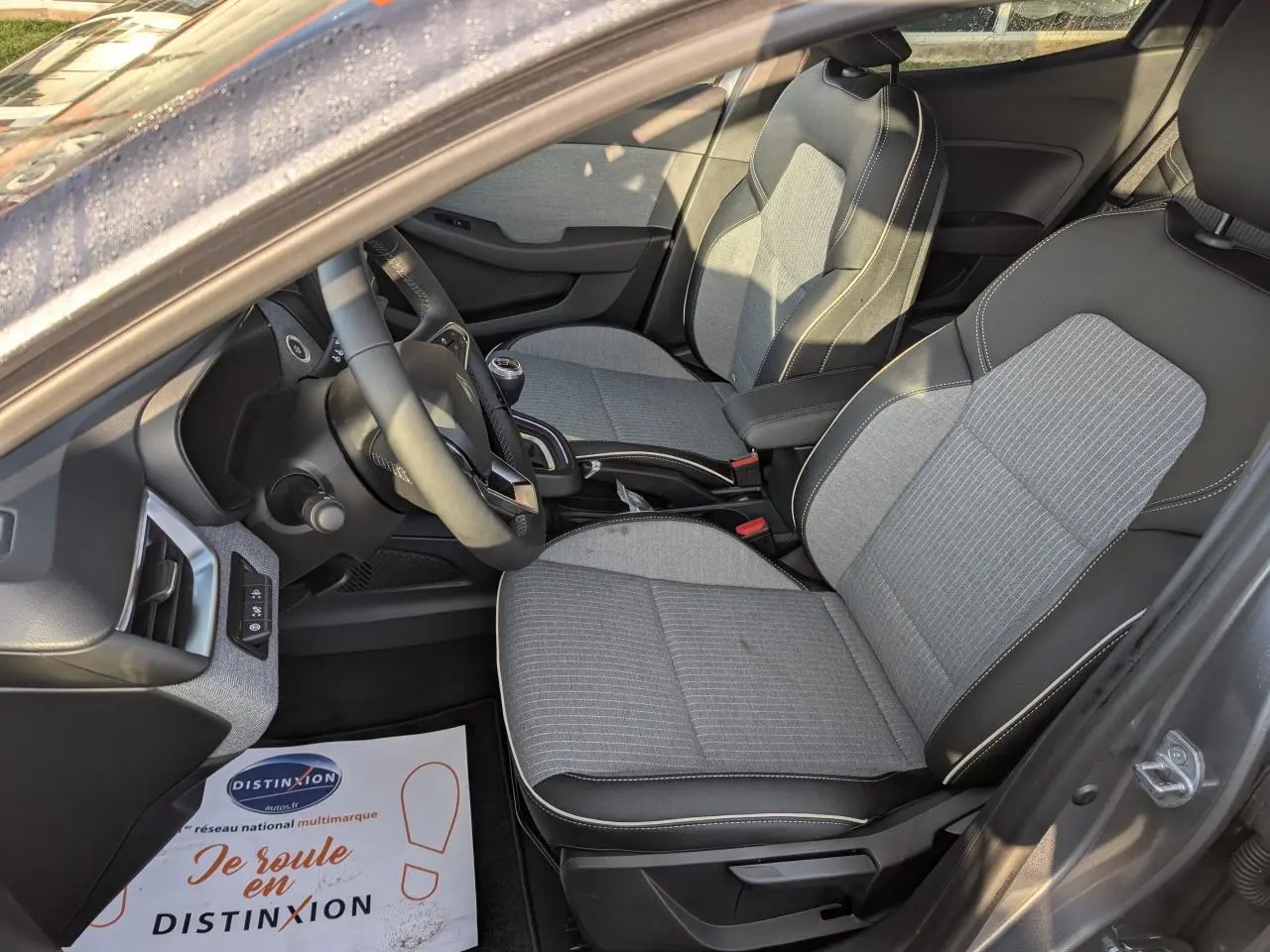 Intérieur avant droit de Renault Clio gris schiste 2025 avec sièges tissu gris et volant multifonction.