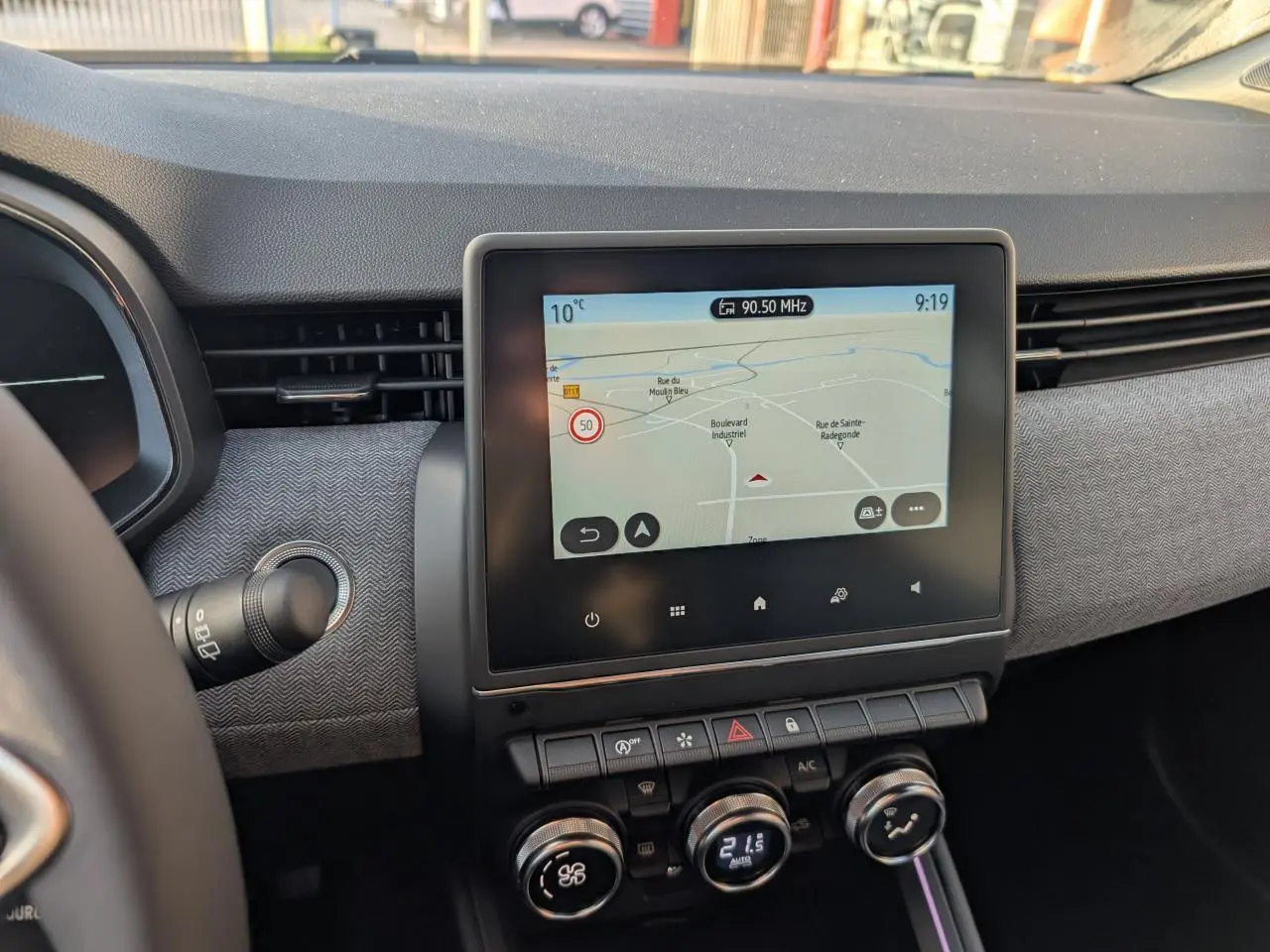 Tableau de bord gris mélangé de Renault Clio 2025 avec écran tactile central affichant la navigation.