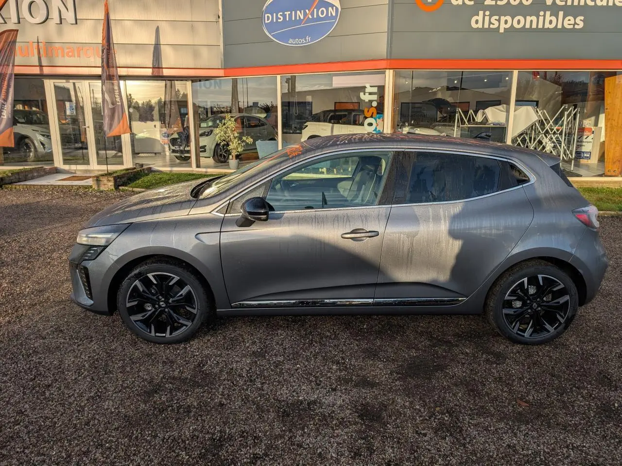 Renault Clio 2025 gris schiste vue de profil côté gauche avec jantes alliage noires et détails chromés extérieurs.