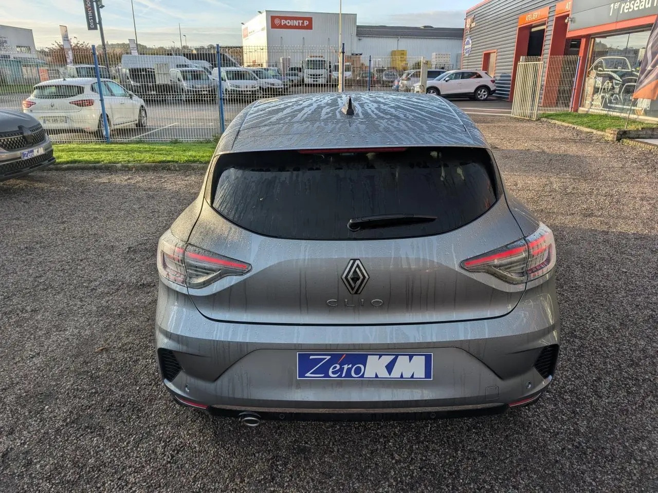 Vue arrière d'une Renault Clio gris schiste 2025 avec feux LED en forme de C et sortie d'échappement chromée visible.