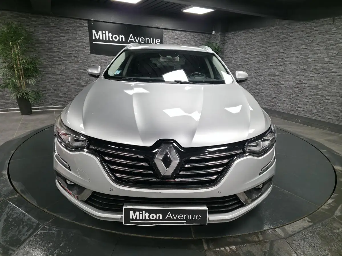 Vue frontale d'une Renault Talisman Estate gris platine avec calandre noire et logo Renault proéminent.