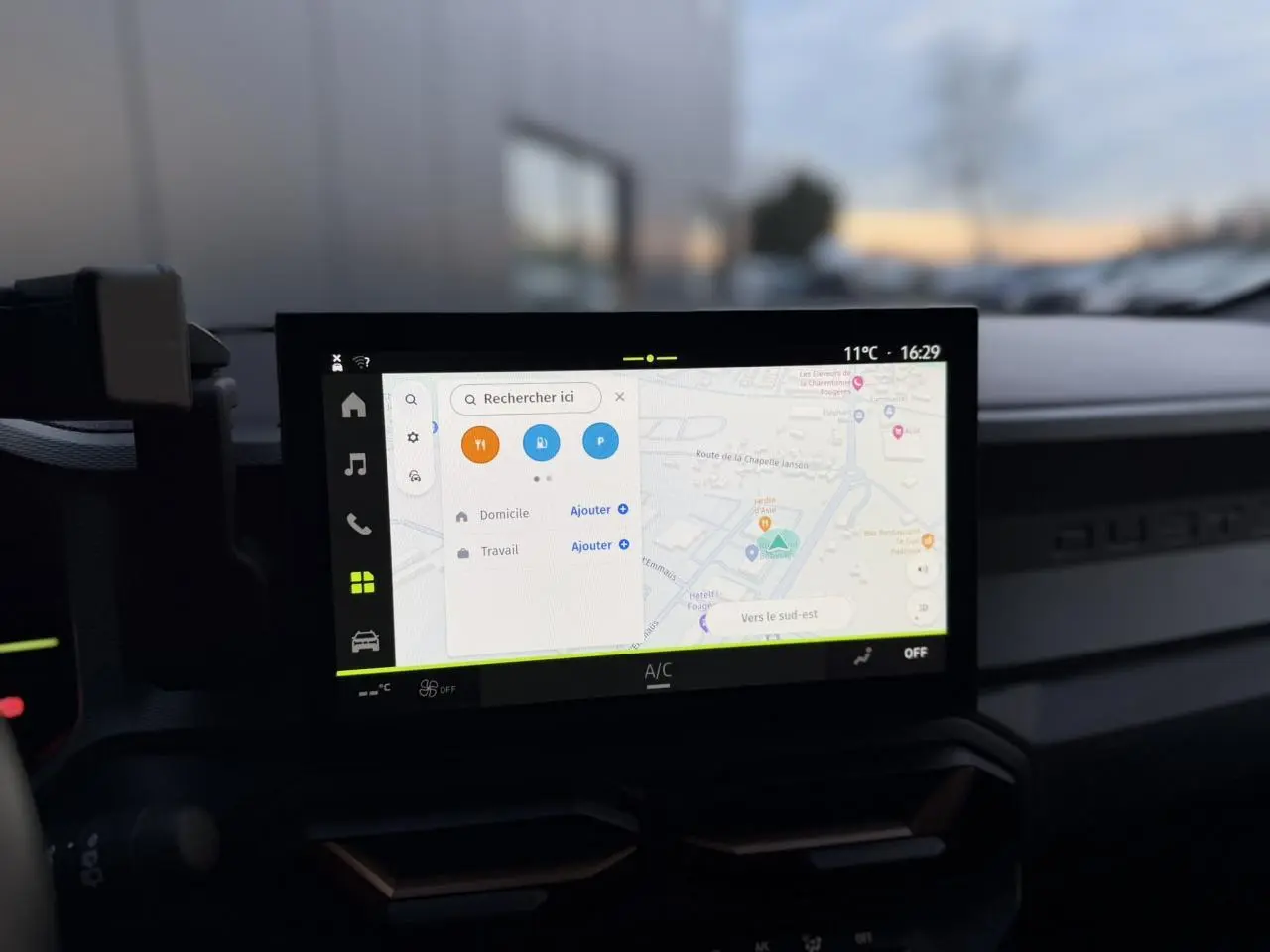 Vue intérieure centrée sur l'écran tactile 10 pouces du tableau de bord du Dacia Duster beige sandstone 2025.