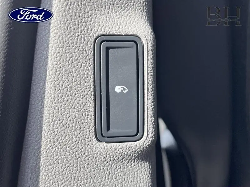 Bouton intérieur noir pour ouverture trappe carburant sur panneau gris clair du Ford Transit Custom Fourgon 2026.