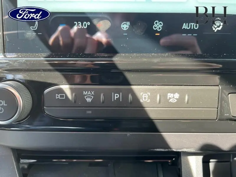 Vue rapprochée du tableau de bord noir du Ford Transit Custom avec commandes tactiles et affichage digital.