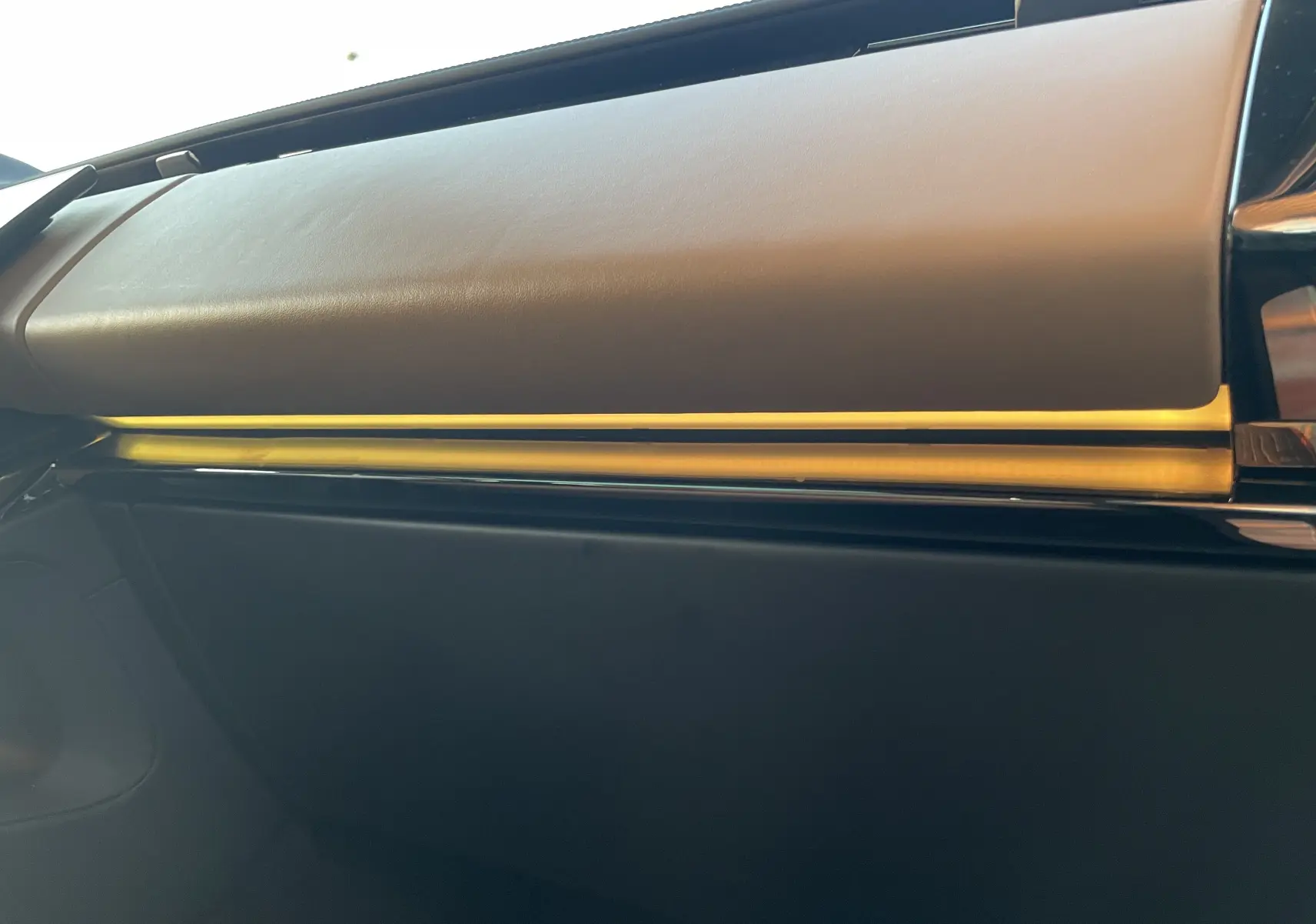 Détail de l’éclairage d’ambiance jaune sur la planche de bord intérieure du Range Rover Sport Carpathian Grey 2023.