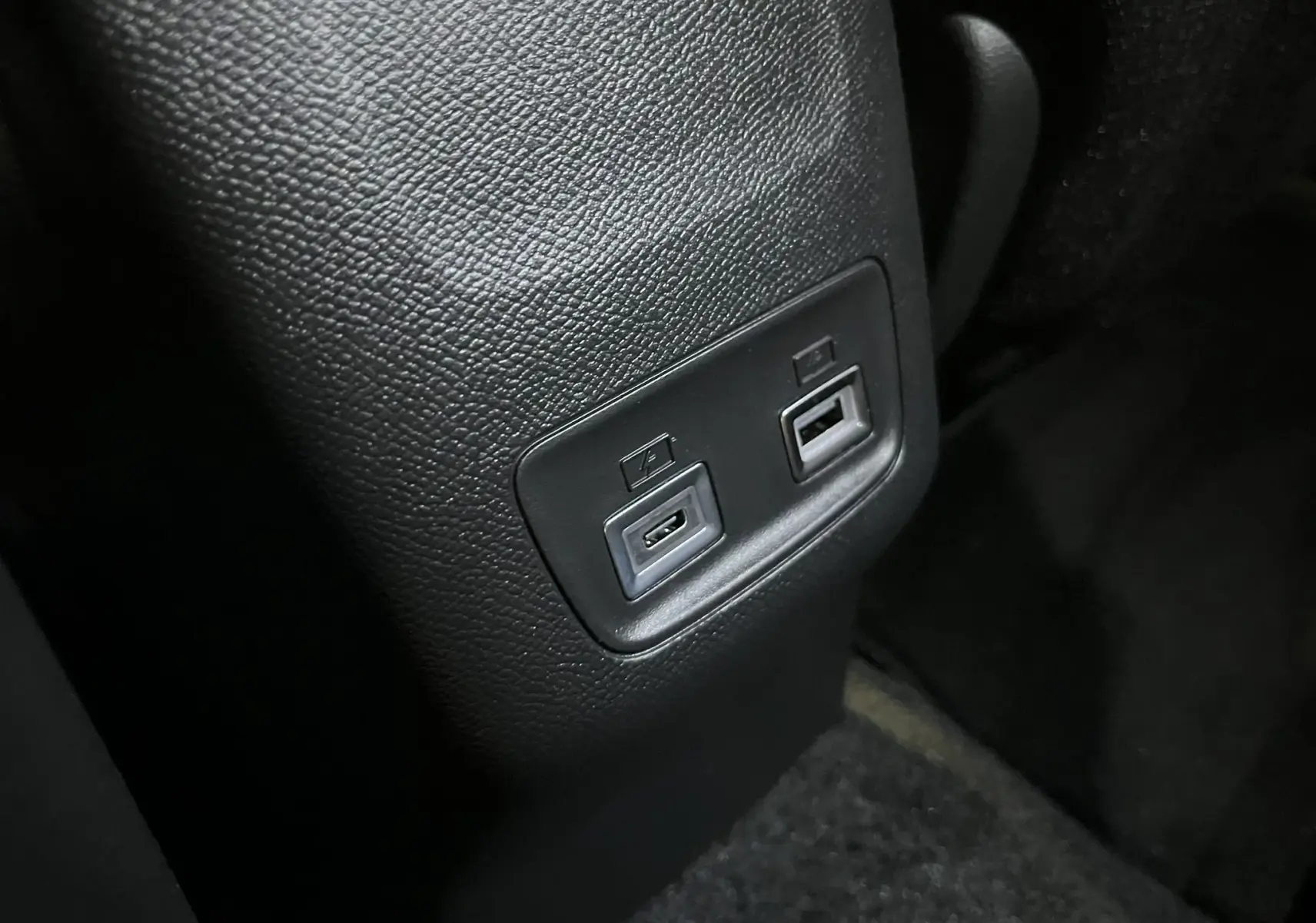 Gros plan sur les ports USB arrière intégrés dans la console centrale noire du Peugeot 2008 gris Artense 2025.