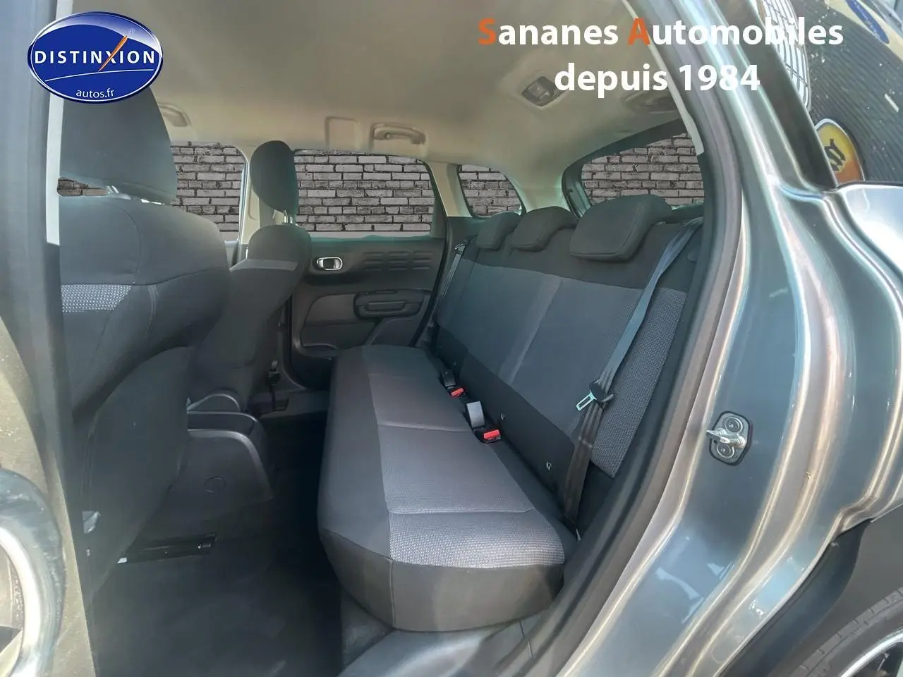 Vue intérieure arrière côté droit du Citroën C3 Aircross gris foncé, montrant la banquette arrière en tissu Mica Grey.