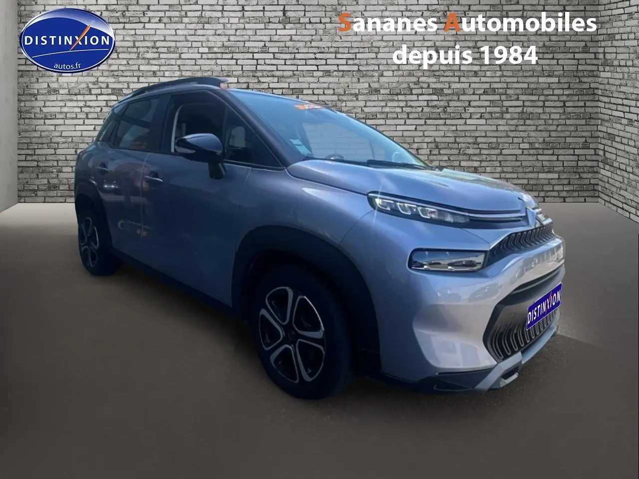 Vue 3/4 avant droit d'un Citroën C3 Aircross gris foncé avec jantes 16 pouces et calandre distinctive.