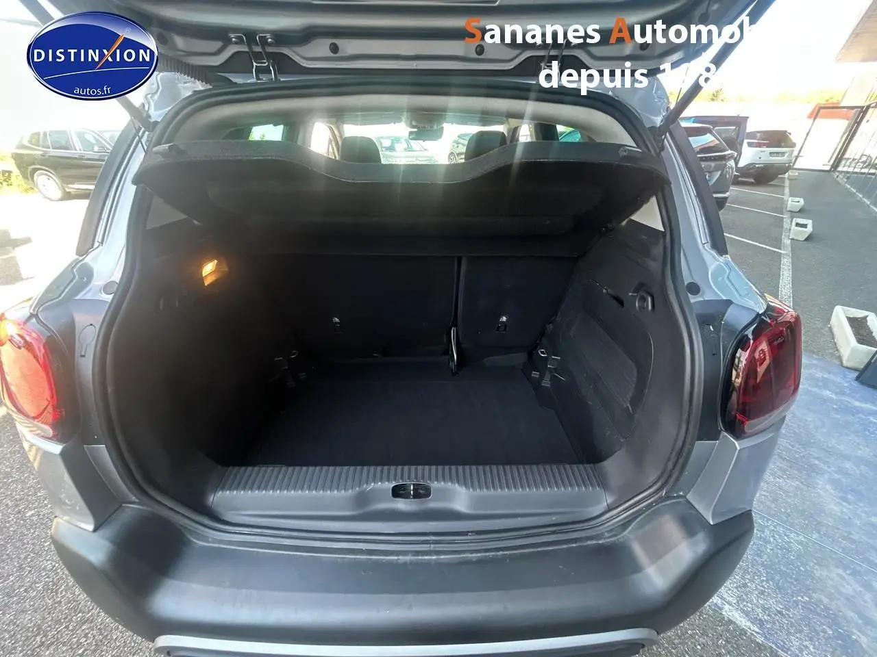 Coffre ouvert vu de l'arrière d'un Citroën C3 Aircross gris foncé, montrant l'espace de chargement vide.