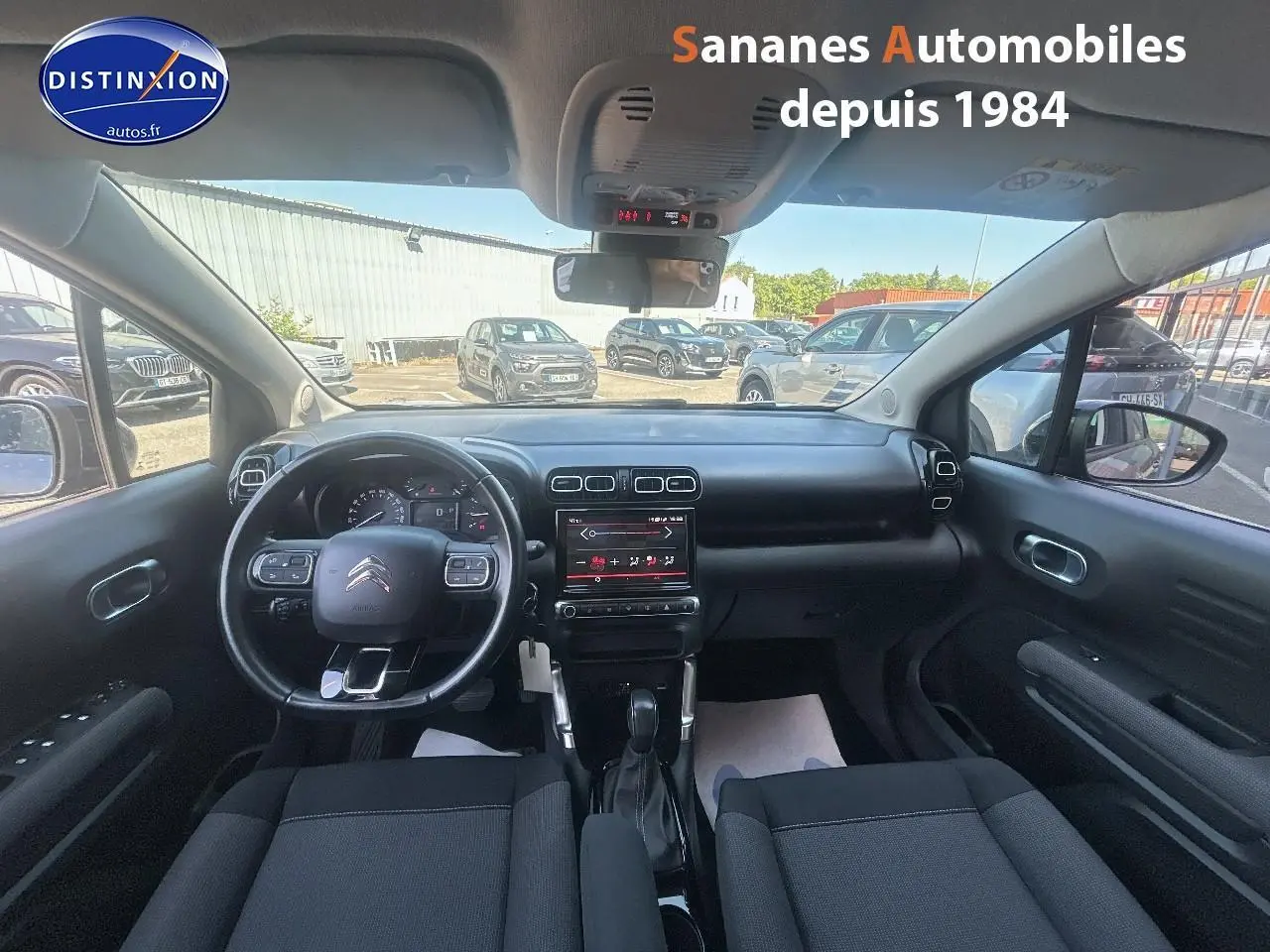Vue intérieure avant du Citroën C3 Aircross 2021, tableau de bord noir avec écran tactile central et volant multifonction.