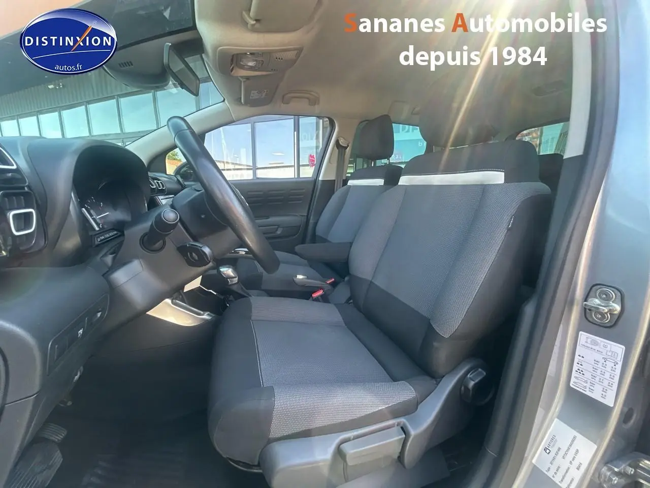 Vue intérieure côté conducteur du Citroën C3 Aircross gris foncé, mettant en valeur les sièges tissu Mica Grey et le volant.