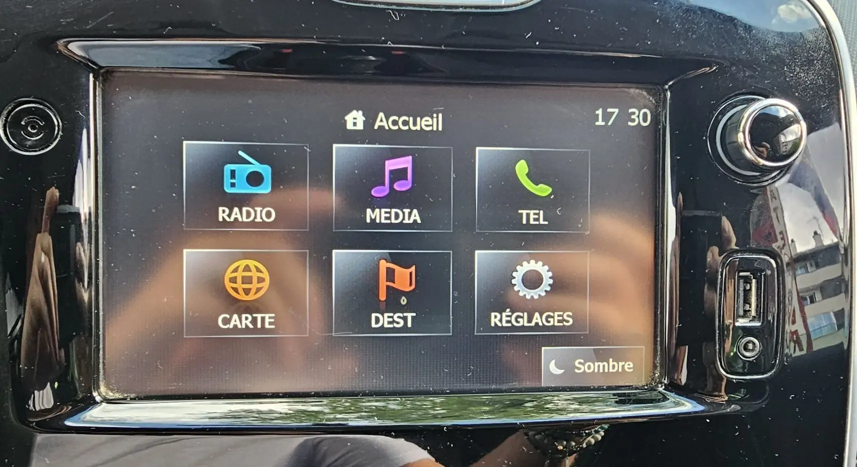 Écran tactile central de la Renault Clio IV grise de 2015 affichant les options radio, média, téléphone, carte, destination et réglages.