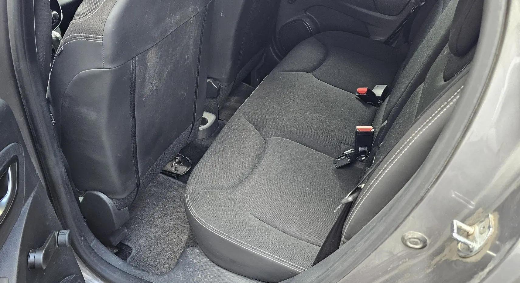 Vue intérieure côté arrière droit montrant la banquette arrière grise d'une Renault Clio IV 2015 finition Zen.