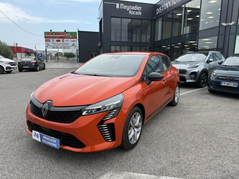 Renault Clio V SCE 65 Evolution orange vue 3/4 avant droit sur parking devant concession Meynadier Rocade