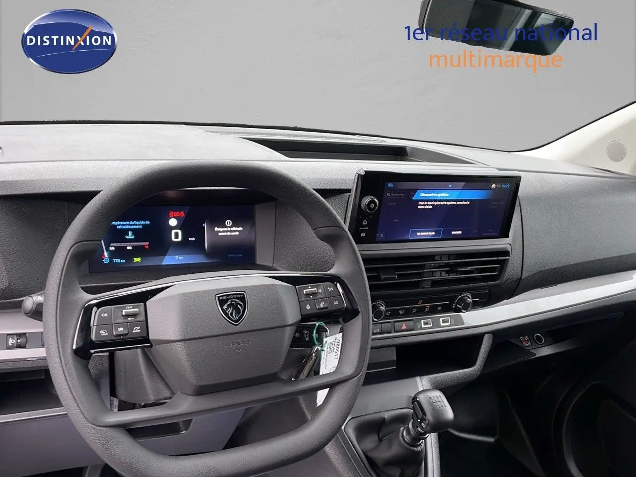 Intérieur du Peugeot Expert Fourgon 2025 vu de face, volant multifonction et écran tactile central sur tableau de bord gris.