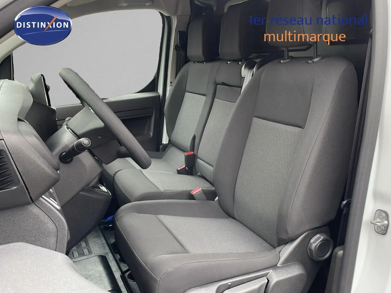 Intérieur avant du Peugeot Expert Fourgon blanc icy 2025, vue côté conducteur montrant les sièges gris et le volant.