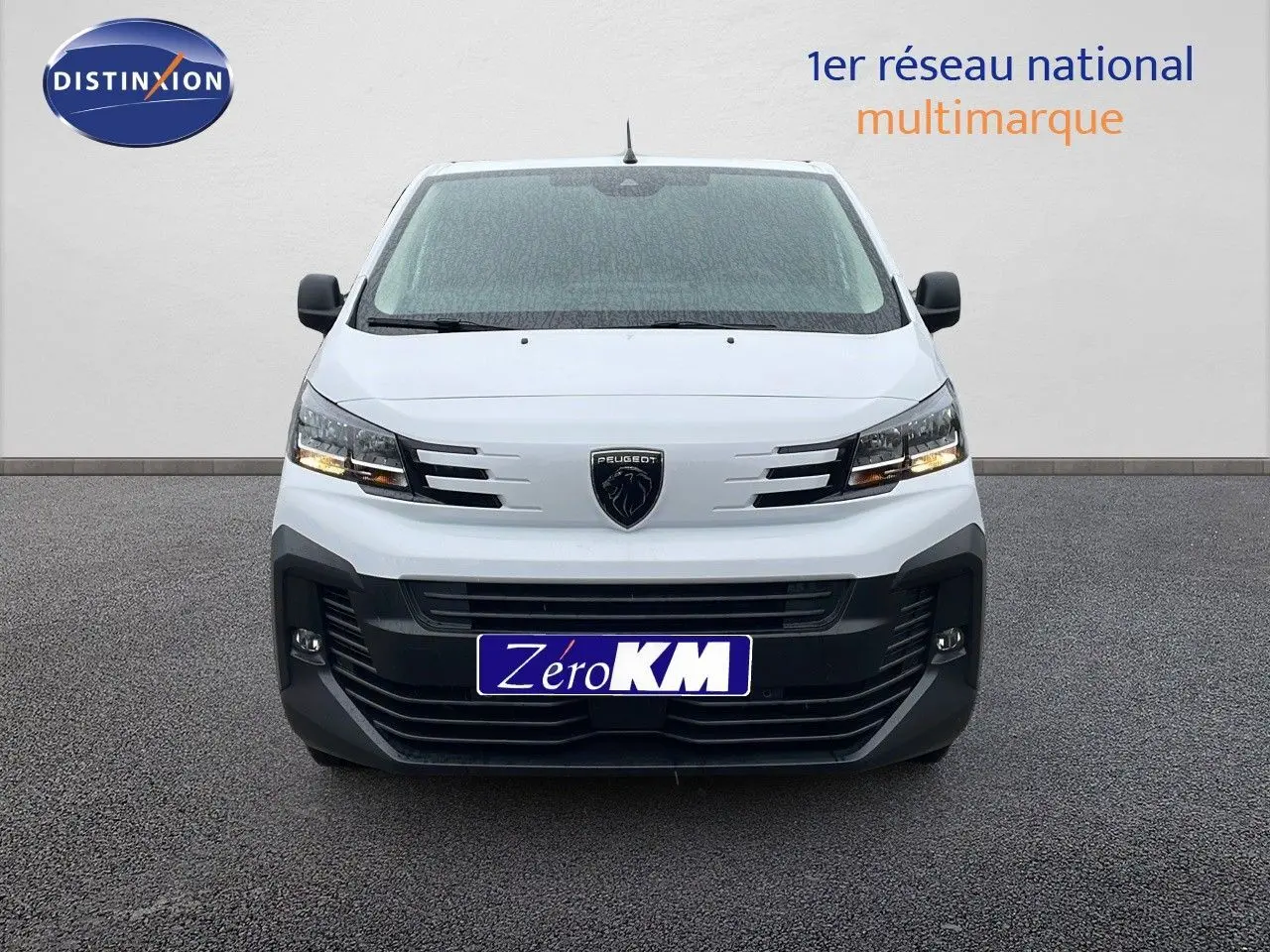 Vue frontale d'un Peugeot Expert Fourgon blanc Icy 2025 avec calandre noire et feux allumés sur fond neutre.