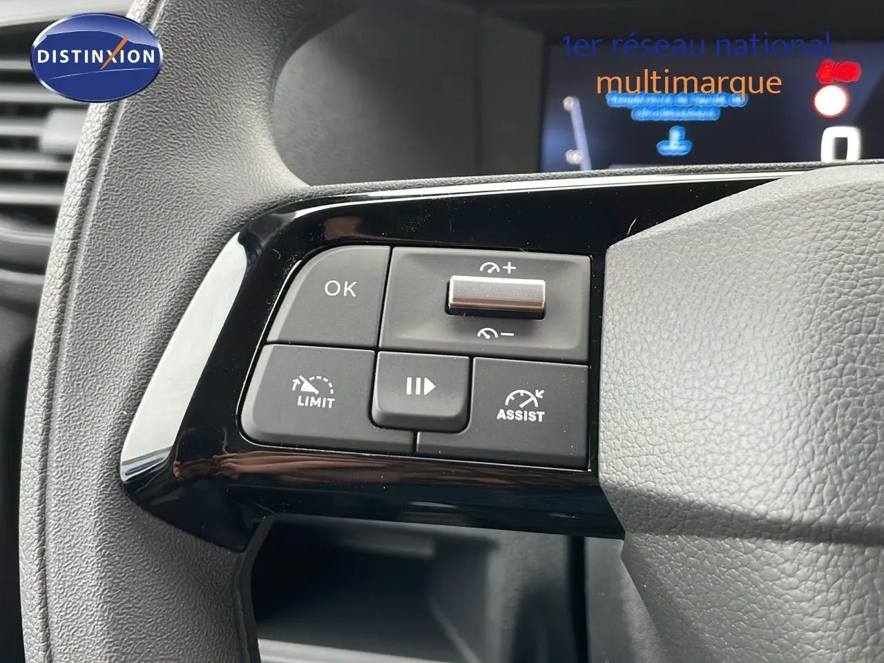Gros plan sur les commandes de régulateur de vitesse au volant gris du Peugeot Expert Fourgon blanc Icy 2025.