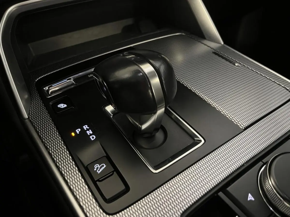 Gros plan sur le levier de vitesses automatique du Mazda CX-60 2023 avec finition noire et inserts argentés.