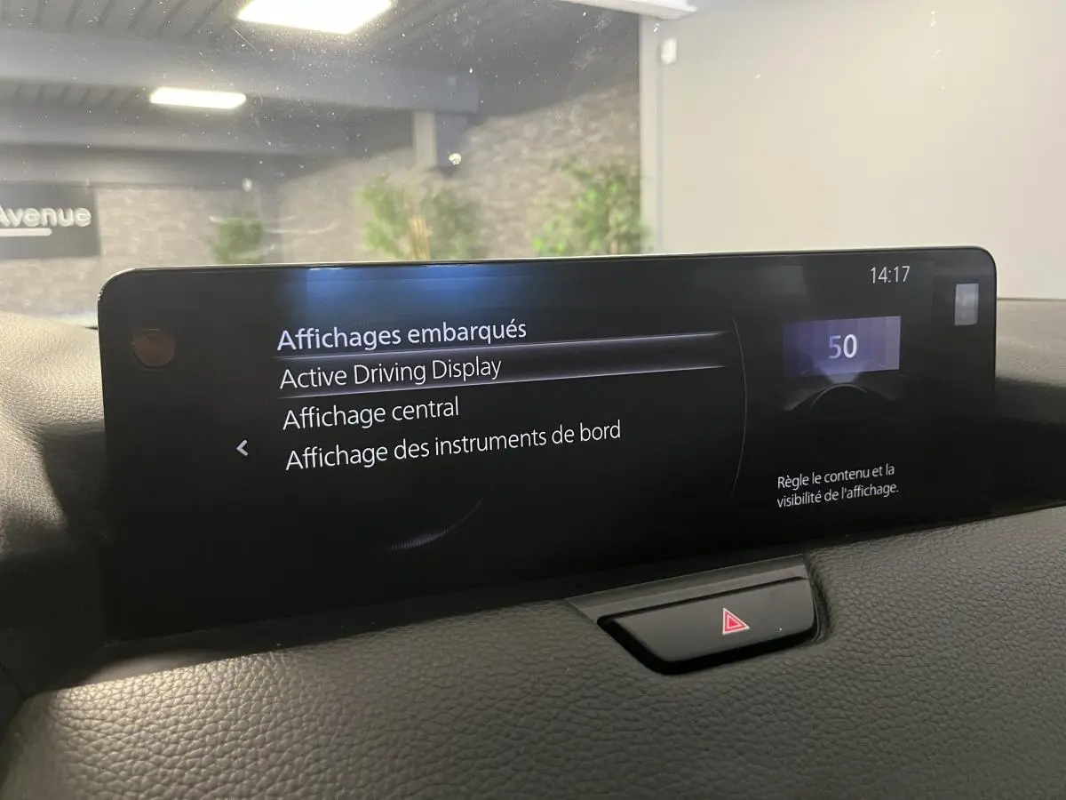 Écran central tactile du tableau de bord du Mazda CX-60 blanc, affichant les options d'affichage embarqué.