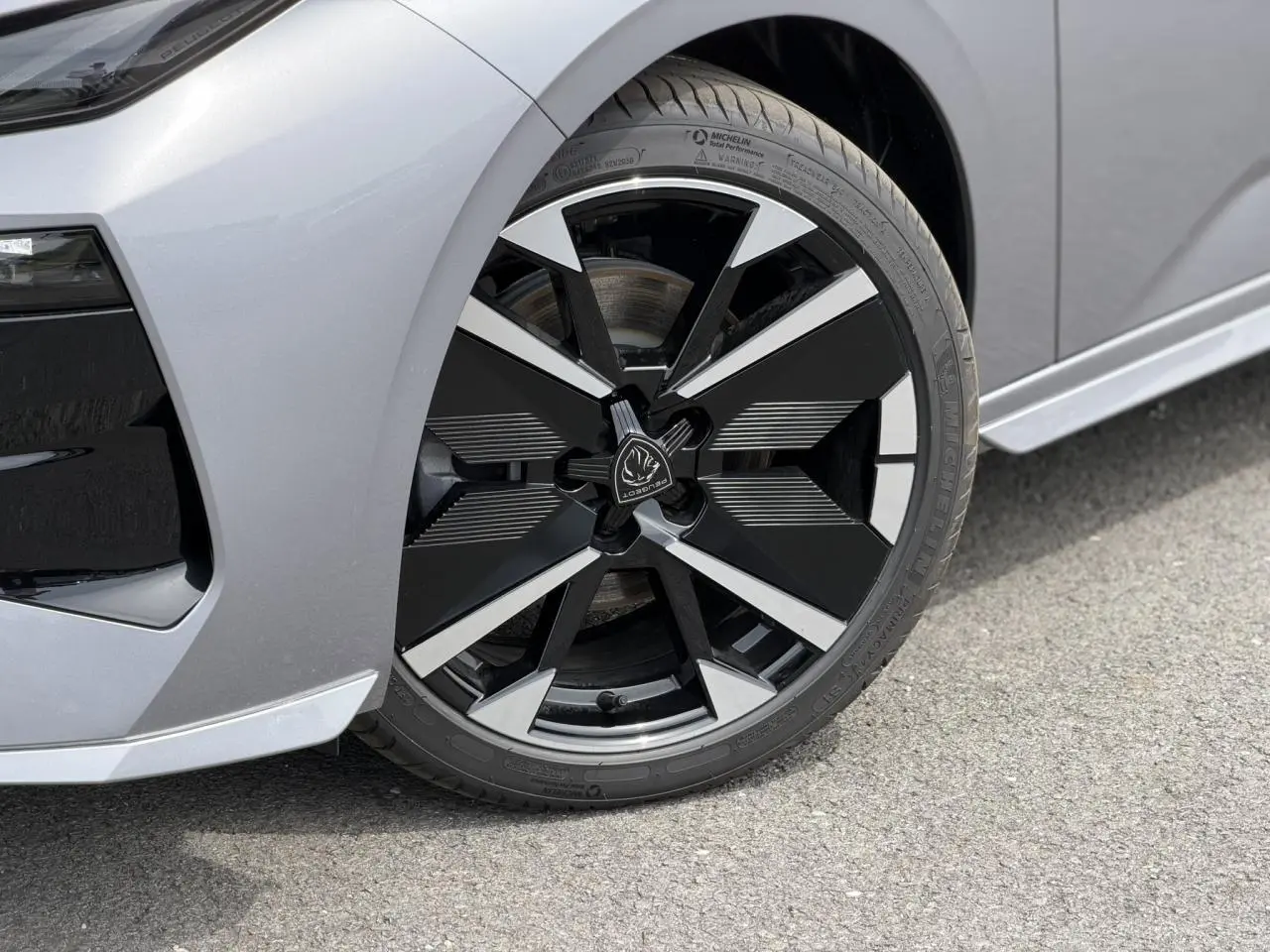 Gros plan sur la jante alliage 18" bi-tons noir et argent du côté avant gauche d'une Peugeot 308 gris Artense.