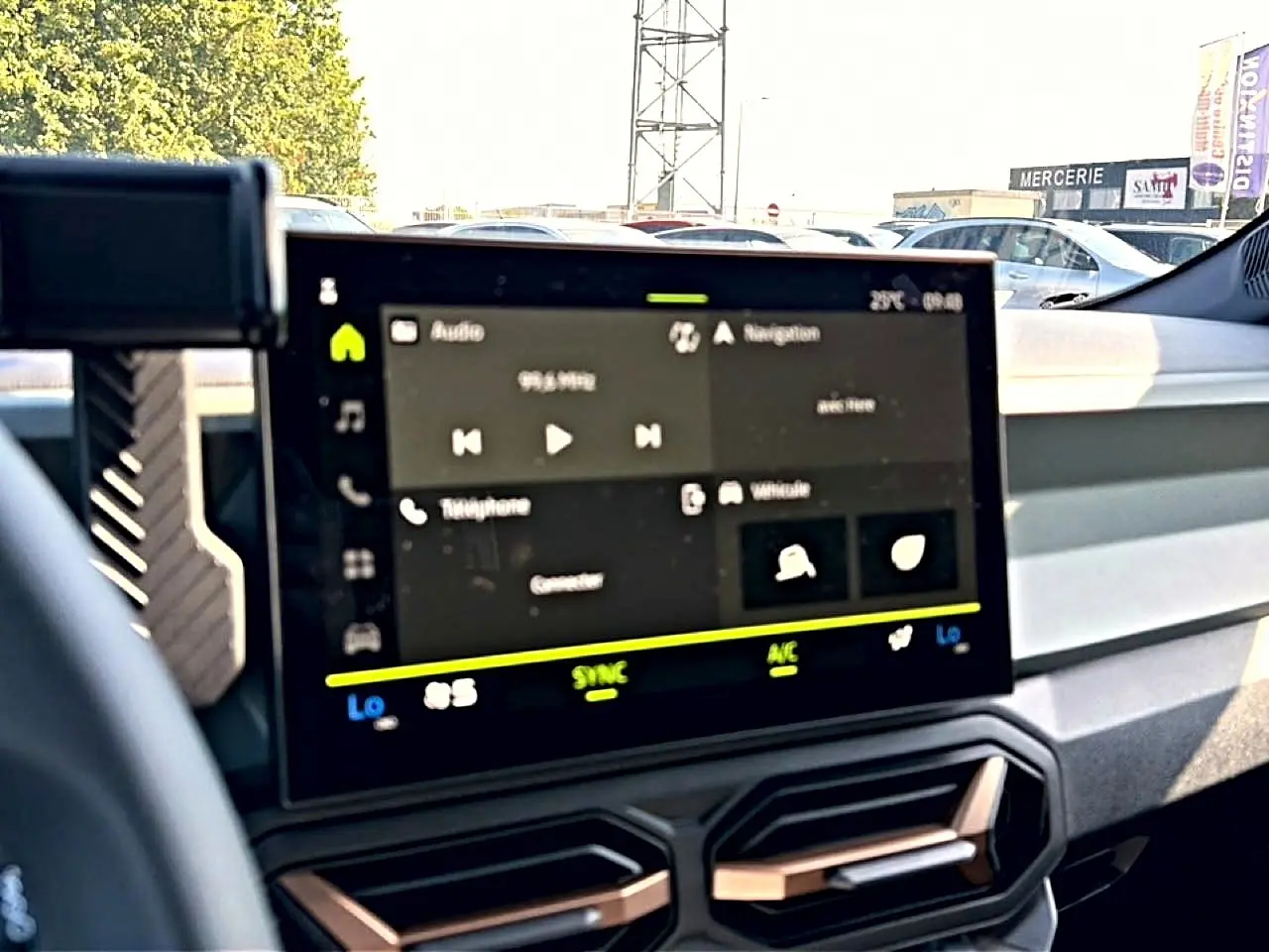 Vue intérieure du tableau de bord du Dacia Bigster 2026 avec écran tactile multifonction et commandes climatisation visibles.