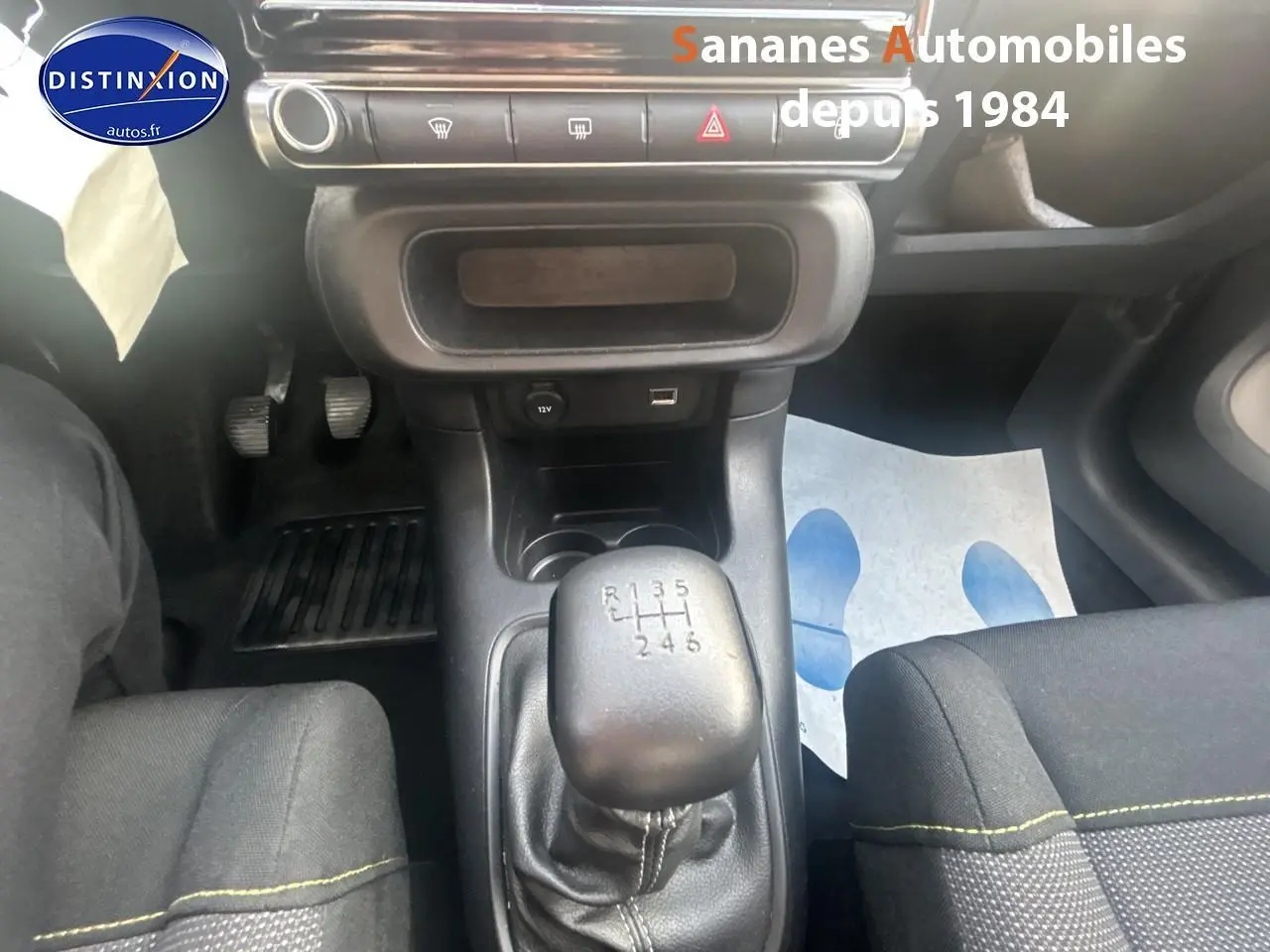 Le levier de vitesses manuel de la Citroën C3 gris foncé 2023 avec console centrale et sièges tissu Mica Grey.
