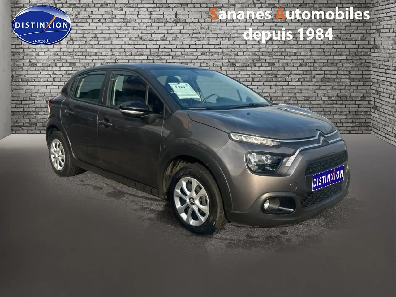 Citroën C3 gris foncé vue 3/4 avant droit avec projecteurs antibrouillard et jantes acier.