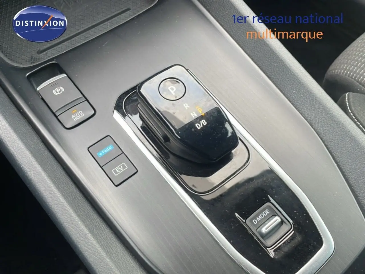 Gros plan sur la console centrale du Nissan Qashqai 2023 noir métal, montrant la commande de boîte automatique et les boutons EV et D-Mode.