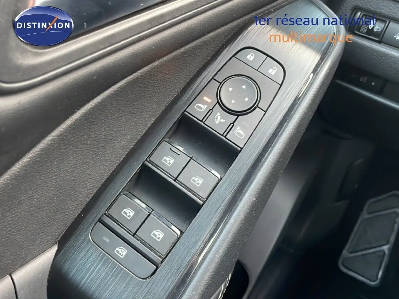 Gros plan sur les commandes de lève-vitres et rétroviseurs côté conducteur du Nissan Qashqai noir métal 2023.