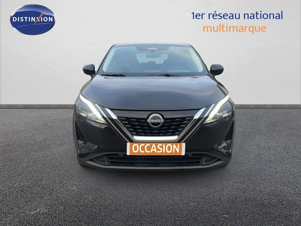 Vue avant d'un Nissan Qashqai noir métal 2023 avec calandre chromée et phares LED allumés.